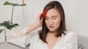 woman holding her head in pain