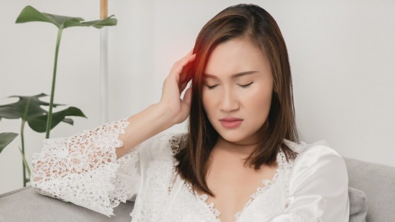 woman holding her head in pain