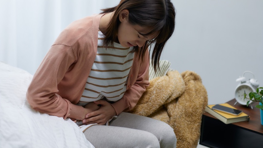woman holding her stomach in pain
